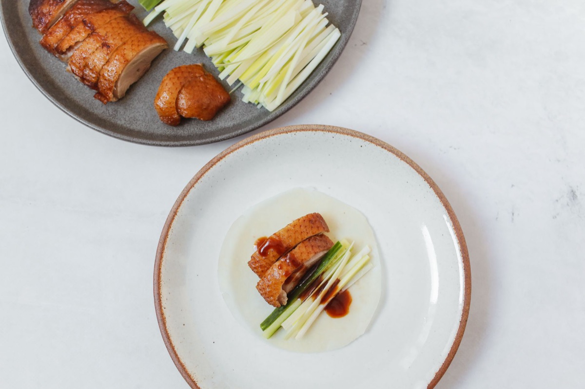 Pelle gialla e caramellata di pollo di Pechino, con texture croccante e bolle d'aria visibili