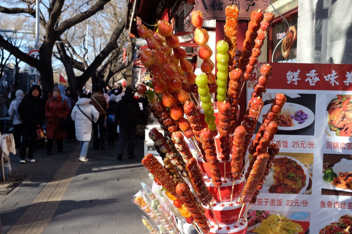 venditore cinese con skewer di maiale marinato
