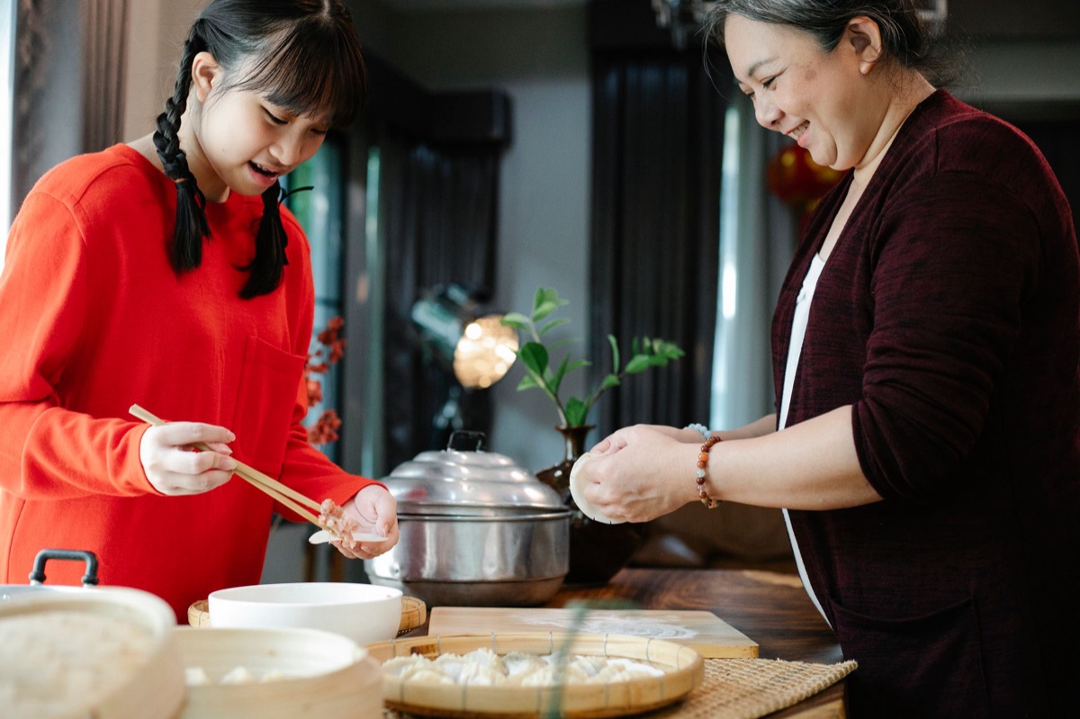 Family cooking dumplings in a Chinese kitchen