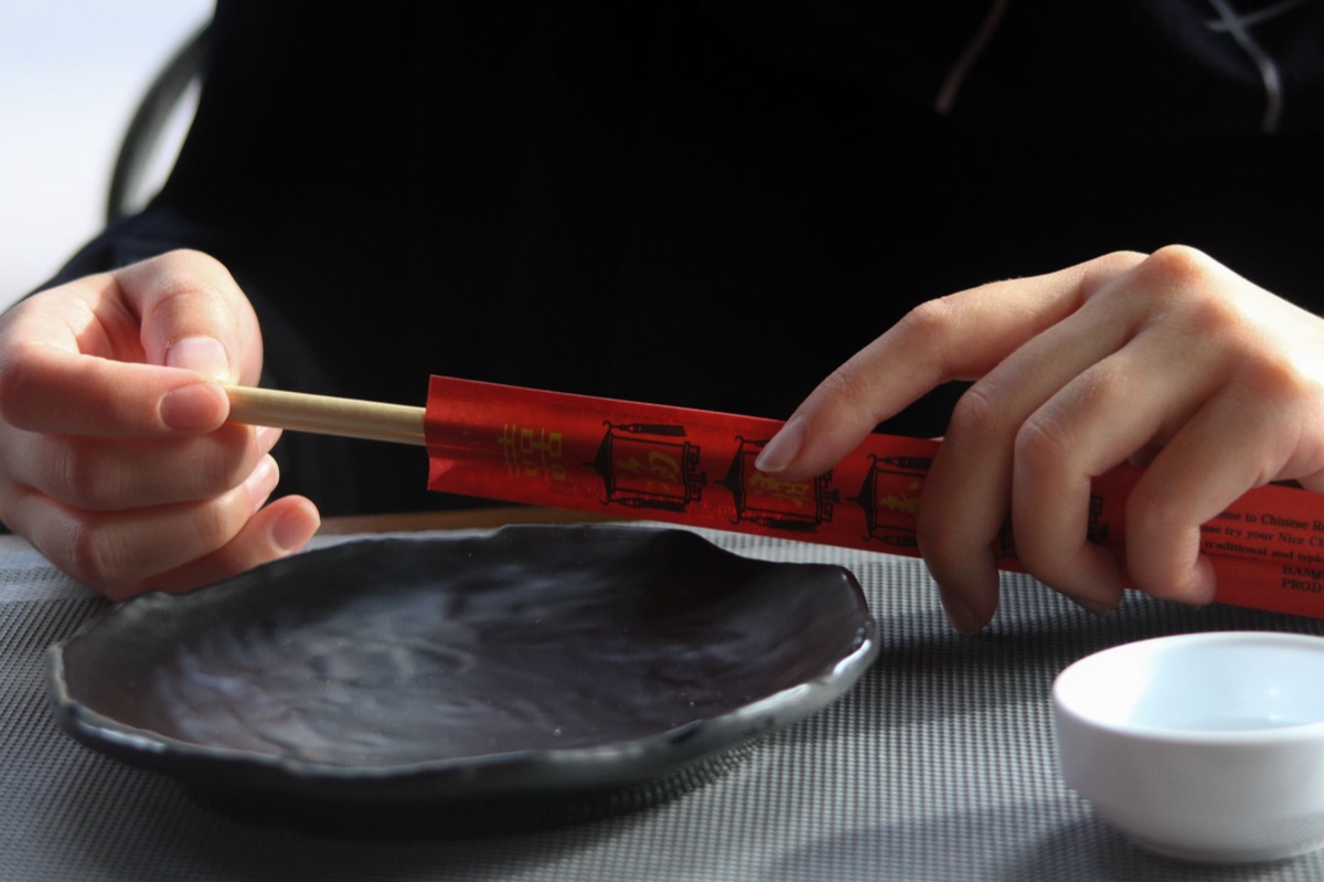 uma pessoa comendo tteokbokki com chopsticks