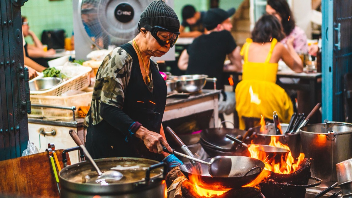 Vendeur de nourriture chinoise avec wok et ingrédients