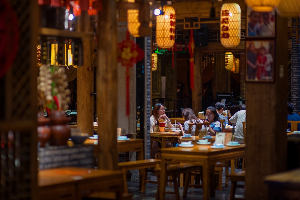 Traditional Chinese restaurant interior with red lanterns and wooden tables